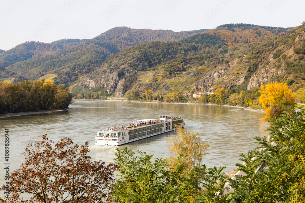 Obraz premium River cruise ship at the river Danube in the Wachau wine-growing area in Austria during autumn