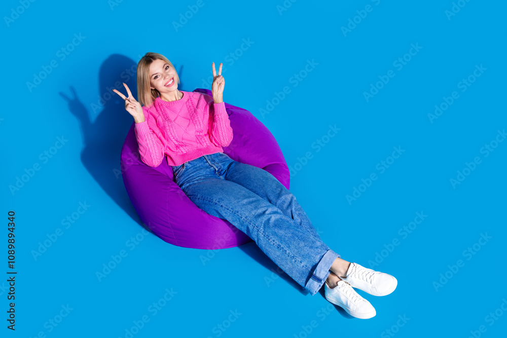 Φωτογραφία Full size photo of pretty young woman beanbag v-sign wear pullover isolated on b