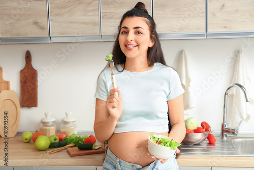 Smiling pregnant woman eati...