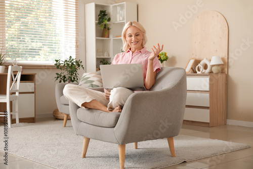 Mature woman with laptop ha...
