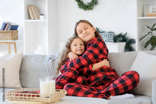 Cute sisters in pajamas hug...