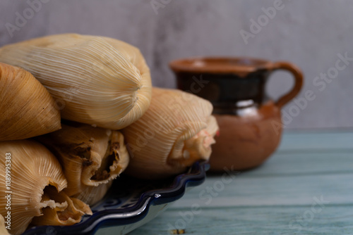 Varios tamales sobre plato, a lado de taza de barro, desayuno mexicano photo