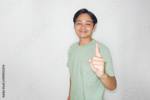 portrait of a handsome Indonesian man in a random mood wearing green clothes