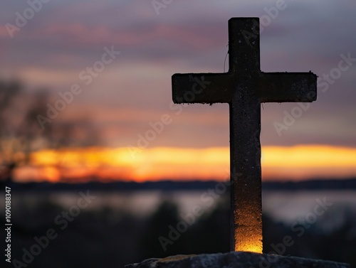 The Christian cross illuminated by a heavenly light against a backdrop of dawn or dusk photo