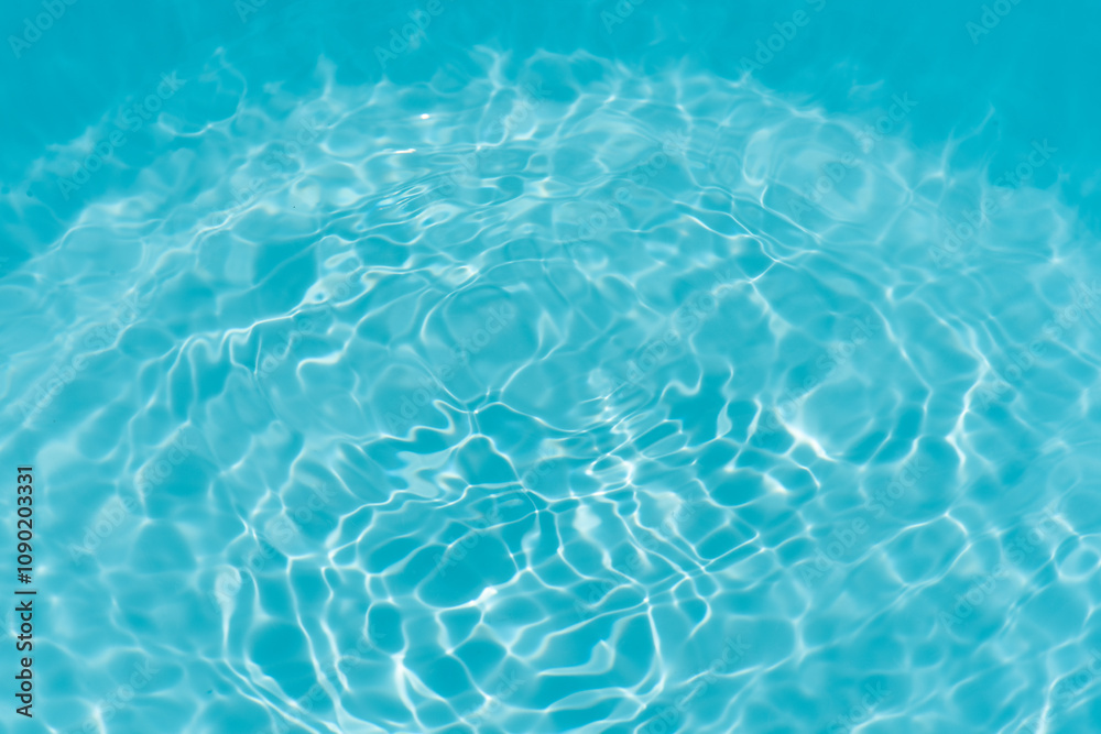 Obraz premium Blue water with ripples on the surface. Defocus blurred transparent blue colored clear calm water surface texture with splashes and bubbles. Water waves with shining pattern texture background.