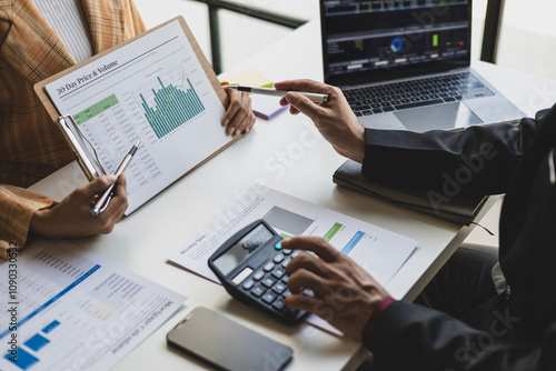 Meeting with a financial advisor and auditor are analyzing the financial figures in the business report. Investors are discussing cost analysis and reducing costs to increase profitability.
