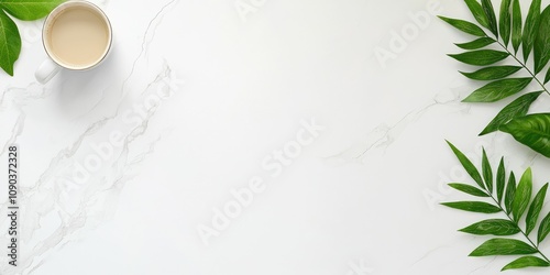Flat lay of coffee cup and green leaves on marble background.