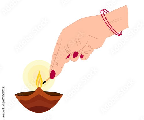A woman’s hand lighting a traditional oil lamp (diya) with a matchstick