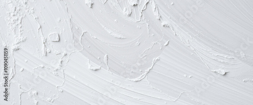 Thick white paint applied with dynamic brushstrokes creates a textured surface on a canvas, offering an abstract background with artistic appeal.