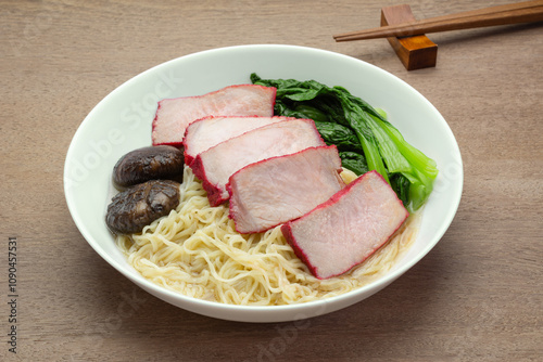 homemade style roasted red pork loin in a ceramic dish serve with soy sauce on wooden table, close up. asian food concept.