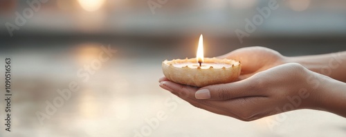 Festival of lights concept. A person holding a lit candle in a serene setting. photo