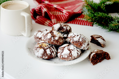 Homemade Cracked chocolate marble cookies for Christmas and cup tea with milk on table. Traditional American chocolate cookies for Christmas