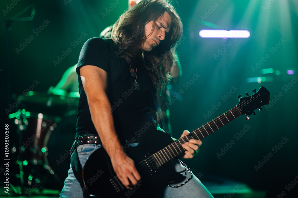Obraz premium Guitarist performing live on stage with band in background