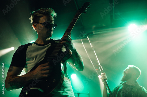 Obraz na plátně Guitarist playing electric guitar on stage during music concert