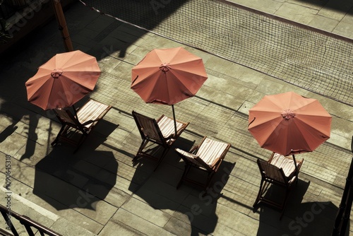 A serene outdoor space featuring three deck chairs and umbrellas casting shadows.