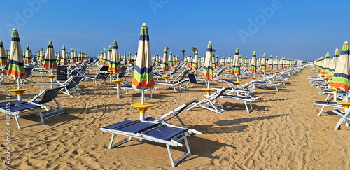 Panorama of the empty beach of Bibione with sun loungers and umbrellas. photo