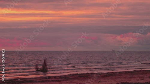 The beautiful sea horizon is covered with clouds illuminated by the setting sun.