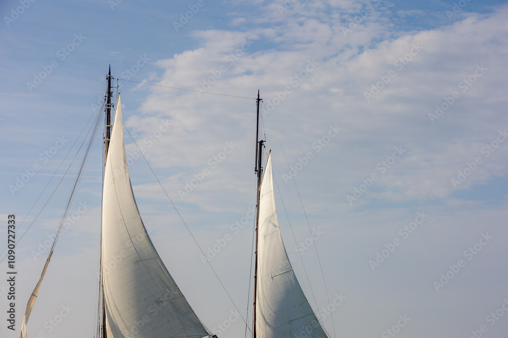 Obraz premium Ocean liner or Sea sailing ship concept, Selective focus of white boat canvas with rops on spar, Sailcloth of sailboat with mainmast and boat hoist rope to spread the sails with blue sky as background