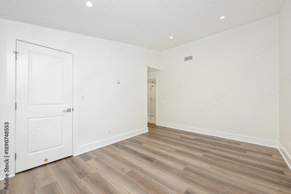 Obraz premium Minimalist empty room with wooden floor and closed door.