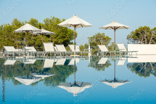 Serene Outdoor Swimming Pool with Lounge Chairs and Umbrellas photo