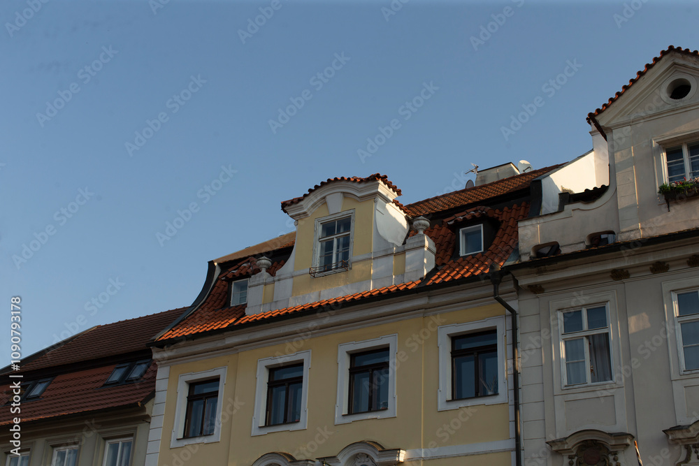 Obraz premium A stunning view of a historic building, showcasing its ornate roof and elaborate facade details, set against the backdrop of a vibrant European city, captivating visitors and tourists alike