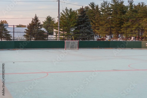 view of an unoccupied roller hockey rink in a city park at dawn