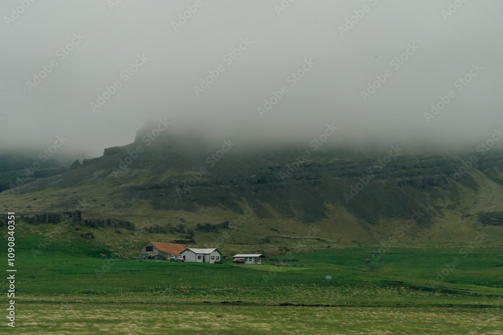 Fototapeta premium rural scene with grazing sheep,rustic farm buildings and a tranquil lake,capturing Iceland countryside charm.