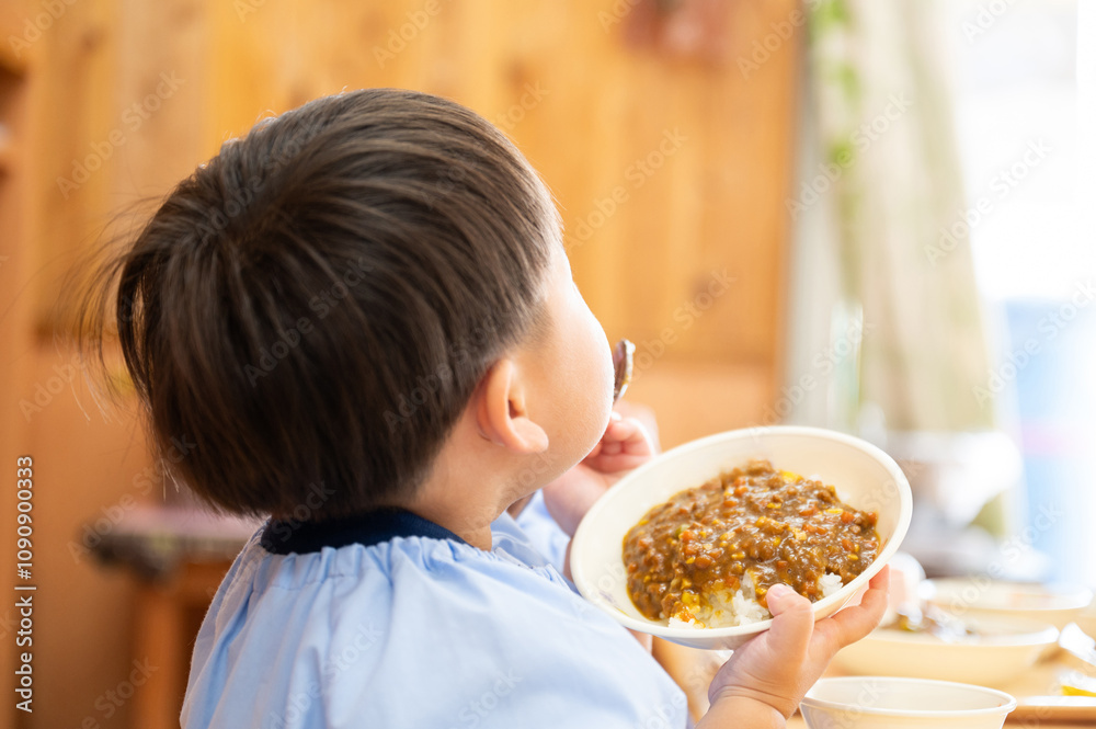 Φωτογραφία 給食のカレーを食べる園児