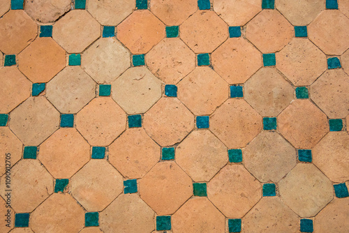 Rustic terracotta tiles adorned with teal ceramic square accents, weathered texture, design element for interiors, marketing, backgrounds or creative projects emphasizing vintage Mediterranean charm.