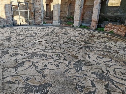 Ostia Antica, Rome, Italy - November 3, 2024. Remains of a building with a large circular mosaic dating back to the Roman Empire, in the Archaeological Park of Ostia Antica.