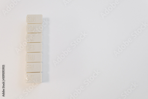Seven white blocks labeled with the days of the week are neatly stacked on a minimalist white surface, symbolizing organization and scheduling techniques