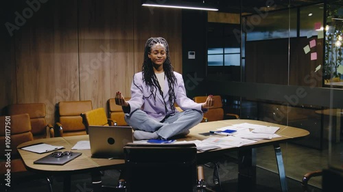 A Meditative Businesswoman in a modern office blends ambition with balance, staying calm and focused in a creative, productivitydriven workspace that inspires innovation and wellness
