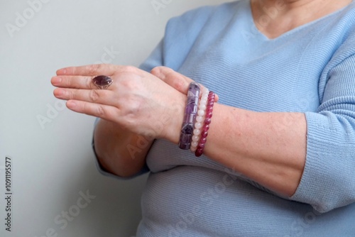 Jewelry made of stones in the hands of an elderly woman. elderly woman in jewelry stones. Bracelets made of stones.
