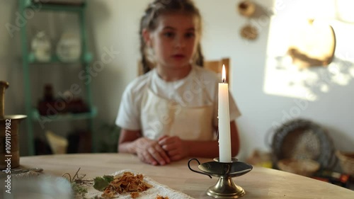 Adorable child blows out a candle, filling the air with a sense of wonder and tranquility. Christmas mood at home