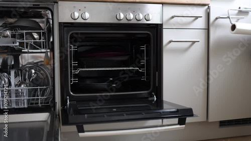Modern kitchen with a dishwasher full of clean plates and utensils. Camera movement to the left