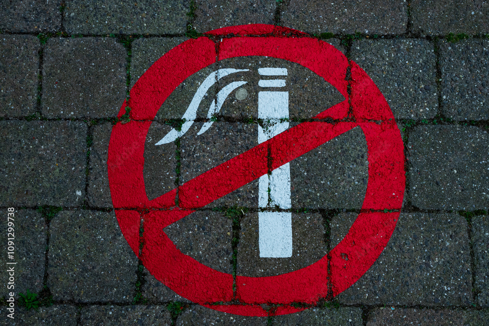 Znak, symbol zakazu palenia namalowany na chodniku.