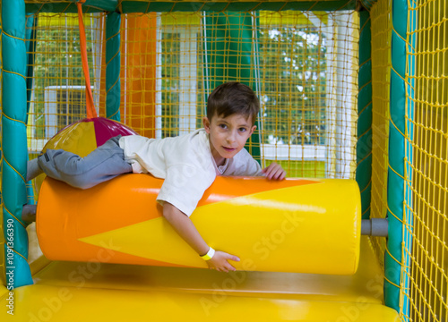 Cute cheerful boy playing from in entertainment center. photo