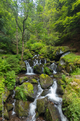 Water wheel mill (Moulin de Chambeuil) with waterfalls, Laveissiere, Cantal, Auvergne-Rhone-Alpes, France photo