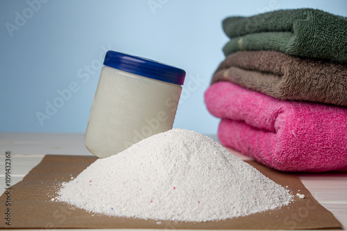 Washing powder and clean towels on a blue background photo