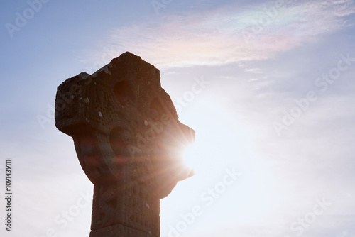 11th-century Celtic Cross at Drumcliffe Church with sunlight shining through, Ireland photo