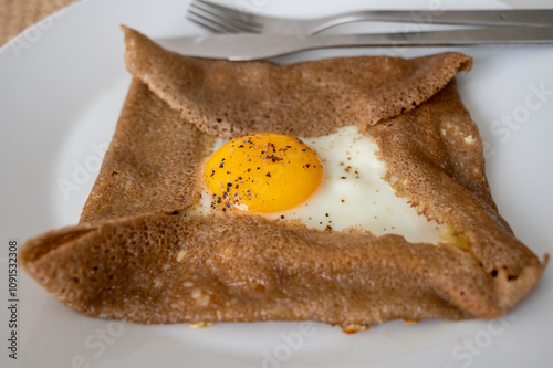 Galettes pancakes from Brittany made with buckwheat flour and served with savoury toppings, smelted cheese and eggs photo