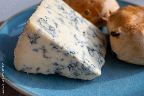 Cheese collection, English cow milk semi-soft, crumbly old stilton blue cheese and baked scones buns photo