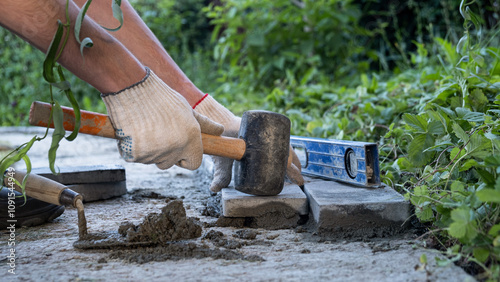 Wallpaper Mural Laying paving stones on cement mortar. Laying a garden path made of tiles. Self-laying of concrete paving slabs in the courtyard of the house. do it yourself. DIY Torontodigital.ca