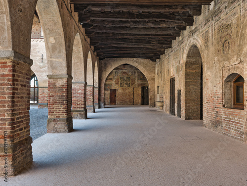 Visconti Castle (14th century), in Pandino near Cremona, Italy. Elegant portico with arches and rustic brick charm.