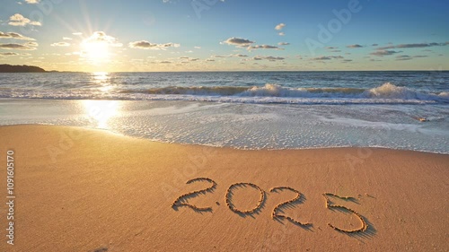 2025 year text symbol written on the seashore sandy beach during sunset. HDR video nature scene. 