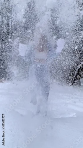 Beautiful sexy girl in a blue suit and top, in the forest in winter, throwing up snow, slow motion.