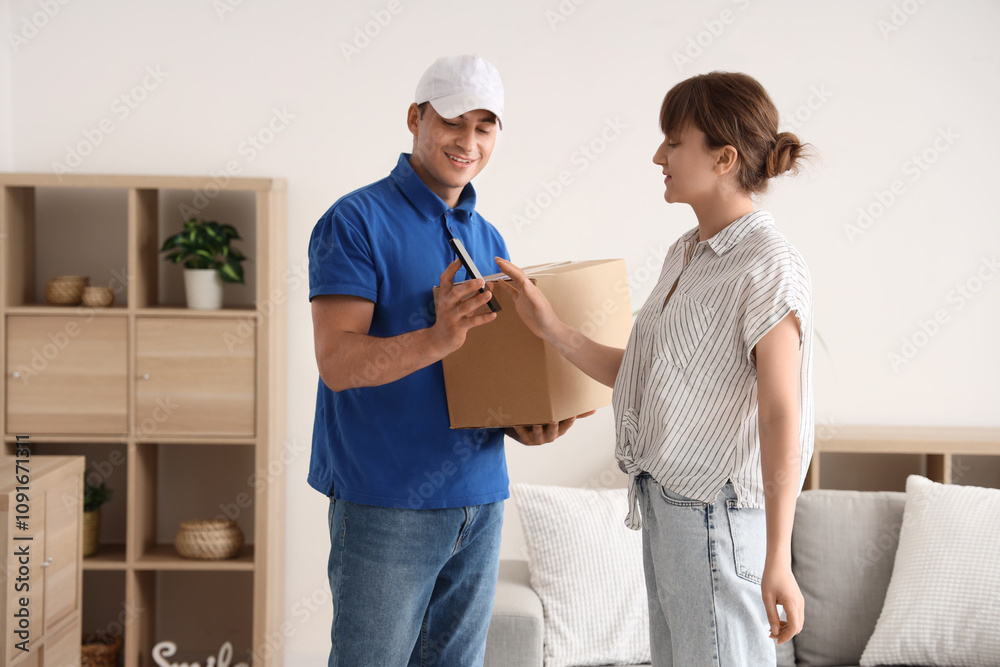 Fototapeta premium Delivery man with mobile phone giving parcel box to woman at home