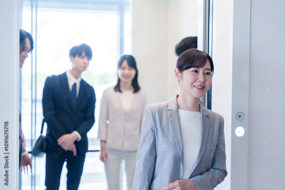 Fototapeta premium オフィスでエレベーターに乗るビジネスパーソン