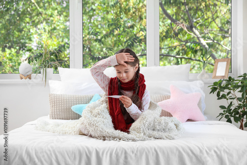 Sick little girl with therm...