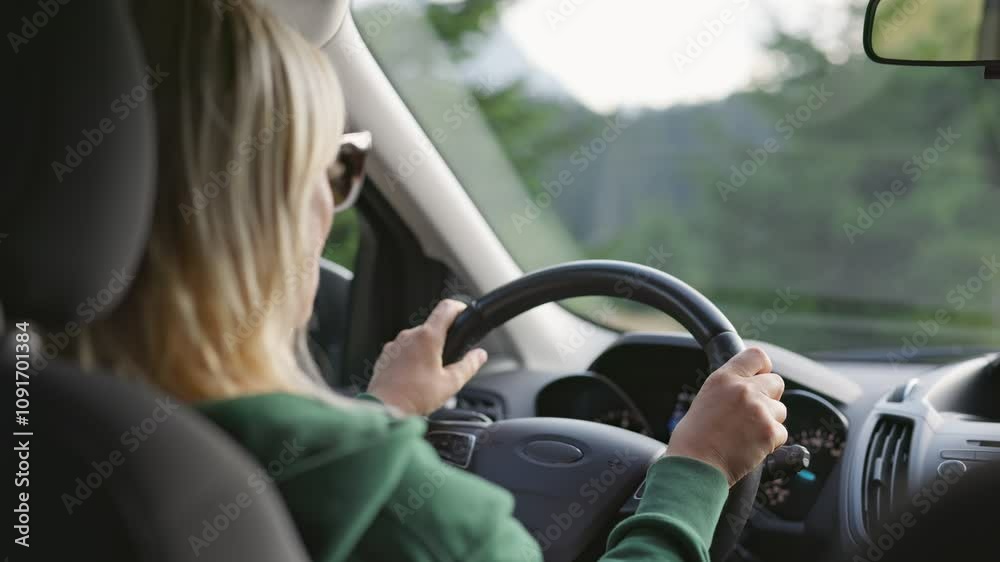 Woman driving through scenic landscape with trees and mountains during late afternoon light. Travel by the car Woman driving through scenic landscape with trees and mountains during late afternoon light. Travel by the car